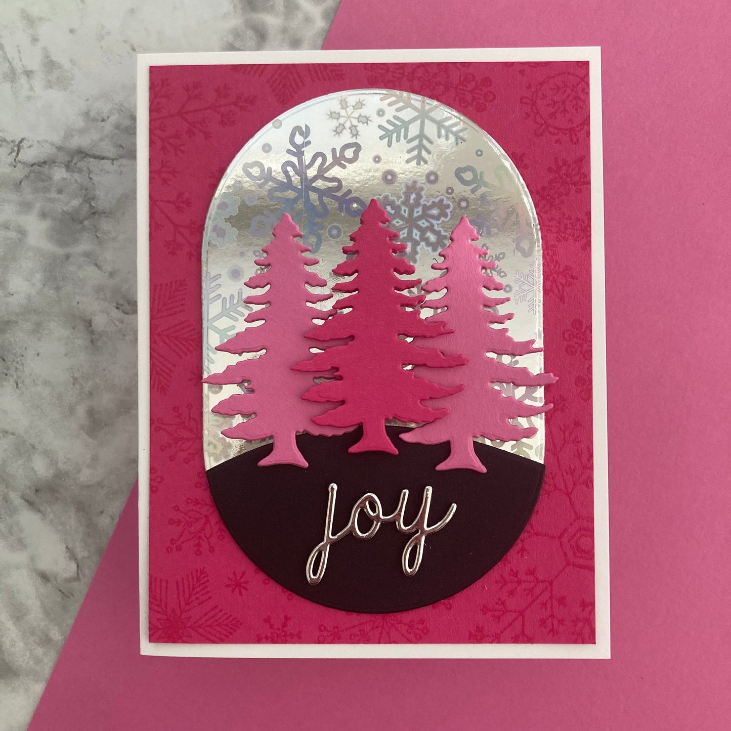 Card with pink trees and 'joy' text on a pink background